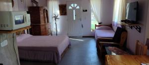 a hotel room with two beds and a television at La Pergola, Sauce Monte Hermoso in Monte Hermoso