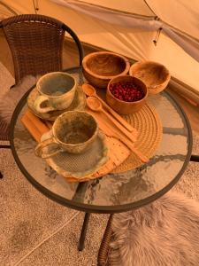 a glass table with bowls of food on top at Karula Stay - Exclusive Glamping Experience with Private Sauna in Ähijärve +10 photos