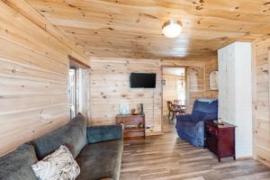 uma sala de estar com um sofá e uma televisão em Wiggin Stream Camp em Greenville
