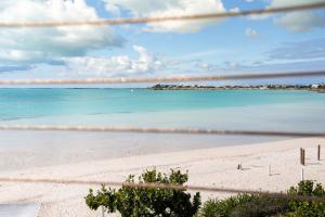 uma vista para uma praia com o oceano ao fundo em SulMare at Sapodilla Bay Luxury villas em Providenciales