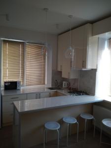 a kitchen with a counter and stools in it at Modern appartment near Sofievka in Umanʼ