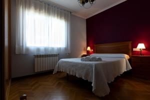 sypialnia z łóżkiem z białym kocem i oknem w obiekcie Playa de Llas w mieście Foz