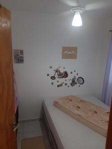 a room with a bed with a motorcycle on the wall at Casa do Jaime in Itapoa