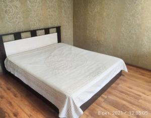 Una cama con una manta blanca encima. en Always at home Apartment OnTransportnaya 11, en Novokuznetsk