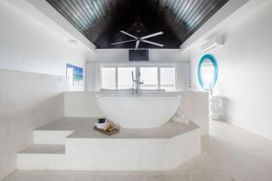 a bathroom with a large white tub and a ceiling fan at SulMare at Taylor Bay Luxury villas in Providenciales