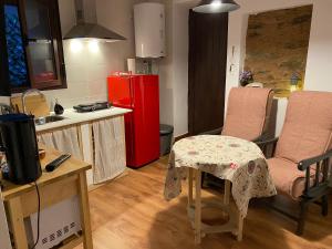 cocina con mesa, 2 sillas y nevera roja en Apartamento rural Prunus avium, en Cambrón