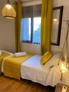 1 dormitorio con 2 camas y ventana en Apartamento rural Prunus avium, en Cambrón