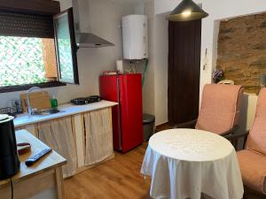 cocina con mesa pequeña y nevera roja en Apartamento rural Prunus avium, en Cambrón