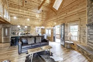 uma sala de estar com um sofá de couro numa cabana de madeira em Lucky Star em Gatlinburg