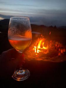 a person holding a glass of wine in front of a fire at Fazenda Rodeio Bonito in Lages