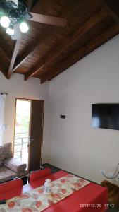 a room with a table and a couch and a television at Departamento Cerro Negro in Villa General Belgrano