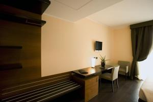 Cette chambre comprend un bureau et un lit. dans l'établissement Red's Redaelli Hotel, à Barzanò
