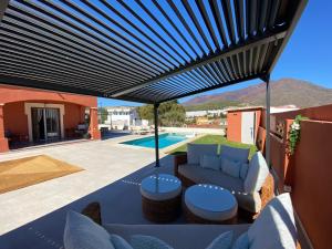 eine Terrasse mit einem Sofa und einem Sonnenschirm in der Unterkunft Casa Delfina in Estepona