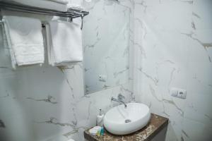 Un baño blanco con lavabo y espejo. en Nice Apartments Tbilisi, en Tiflis 57 fotos más