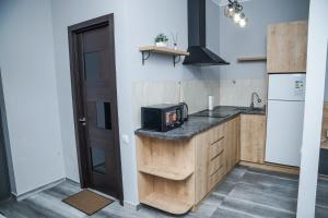 una cocina con encimera con microondas y nevera en Nice Apartments Tbilisi, en Tiflis