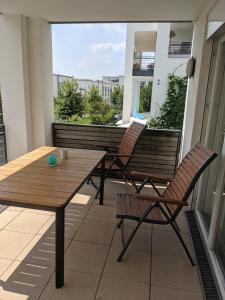 einen Balkon mit 2 Bänken, einem Tisch und Stühlen in der Unterkunft Ferien am Wasser in Wiesbaden