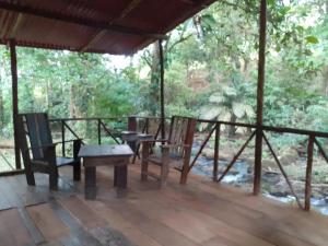 Puerto Viejo的住宿－Vanilla Jungle Lodge - Rainforest Waterfall Garden，门廊配有2把椅子和桌子