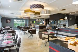 a restaurant with tables and chairs and a bar at Comfort Hotel ORLY-RUNGIS in Rungis