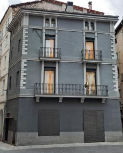 un edificio gris con balcones a un lado en L'Astrolabi en Ripoll