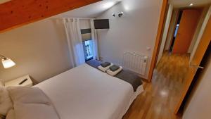 a bedroom with a large white bed and a window at L'Astrolabi in Ripoll
