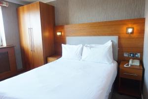 a bedroom with a white bed and a telephone at The Park Hotel in Liverpool