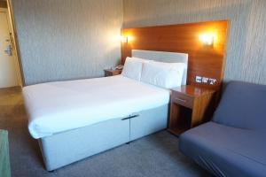 a bedroom with a large bed and a desk and a bed sidx sidx at The Park Hotel in Liverpool