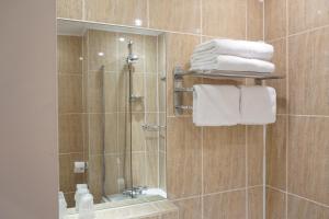a bathroom with a shower with a mirror and towels at The Park Hotel in Liverpool