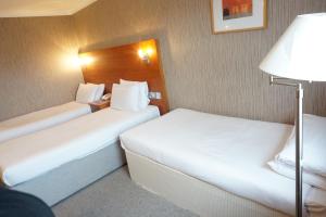 a hotel room with two beds and a lamp at The Park Hotel in Liverpool