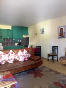 sala de estar con sofá marrón y armarios verdes en Casa à Porta do Torreão, en Silves