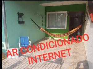 a house with a hammock and a chair in it at Casa do Jaime in Itapoa