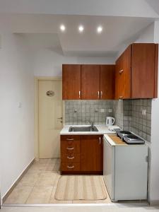 kuchnia z drewnianymi szafkami i białą lodówką w obiekcie 1BD - Deer Traveler Central Apt w Salonikach