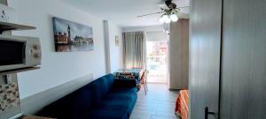 ベナルマデナにあるBenalmadena Aguila apartment sea viewのリビングルーム(青いソファ、テレビ付)