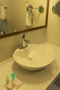 - białą umywalkę w łazience z lustrem w obiekcie VO´E w mieście San Cristóbal de Las Casas