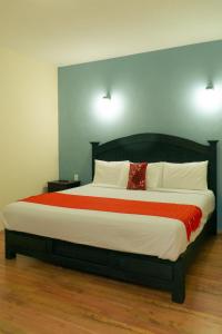 - une chambre dotée d'un grand lit avec des draps blancs et rouges dans l'établissement VO´E, à San Cristóbal de Las Casas