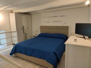 a bedroom with a bed with a desk and a tv at IL GECO in Naples