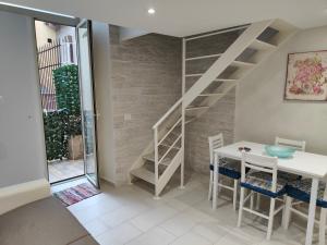 a dining room with a staircase and a table and chairs at IL GECO in Naples