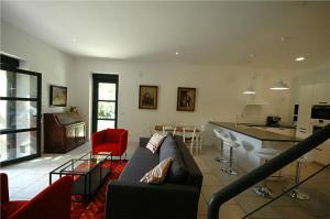 uma sala de estar com um sofá e uma cozinha em Gîte de charme à 15mn de Bordeaux Autonomie 100% em Camblanes-et-Meynac