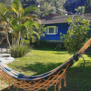 a hammock in a yard in front of a house at Pousada Casa Azul in Lumiar