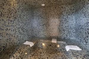 a bathroom with a marble wall and a black and white tiled floor at The Originals Boutique, Hôtel d'Alsace, Strasbourg Sud (Qualys-Hotel) in Illkirch-Graffenstaden