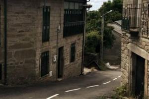 una calle vacía junto a un edificio de ladrillo en La Casa Verde en Sanabria de 4 habitaciones y 2 baños, en Cerdillo