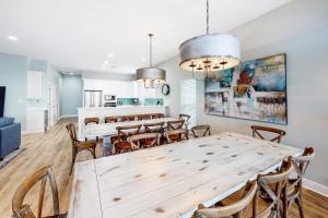 een eetkamer met een grote houten tafel en stoelen bij 2 Carats East in Gulf Shores