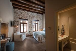 a bedroom with a bed and a stone wall at Serenissima Boutique Hotel in Chania