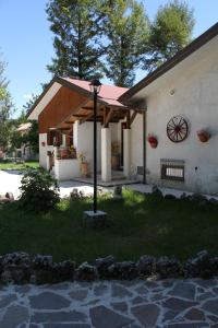 a house with a porch and a clock on the side of it at Rifugio Del Pettirosso in Pescasseroli