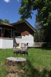 un edificio con un banco en un campo de césped en Rifugio Del Pettirosso en Pescasseroli