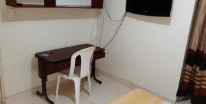 un pequeño escritorio con una silla junto a la pared en cambulos 2, en Cali