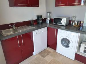 a kitchen with a washing machine and a microwave at Le Gîte du Moulin in Sarrians