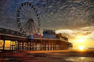 a ferris wheel on a pier at sunset at Lyndhurst Hotel in Blackpool