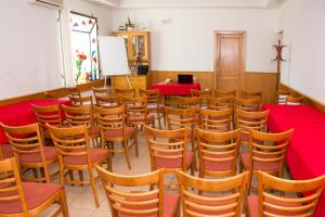 Denis Panzió és Étterem في لينتي: غرفة بها طاولات وكراسي وطاولات حمراء