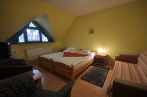 a small bedroom with a bed and a window at Denis Panzió és Étterem in Lenti