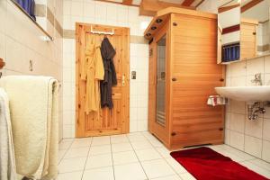 baño con puerta de madera y lavamanos en Holiday flat, Clausthal-Zellerfeld en Clausthal-Zellerfeld